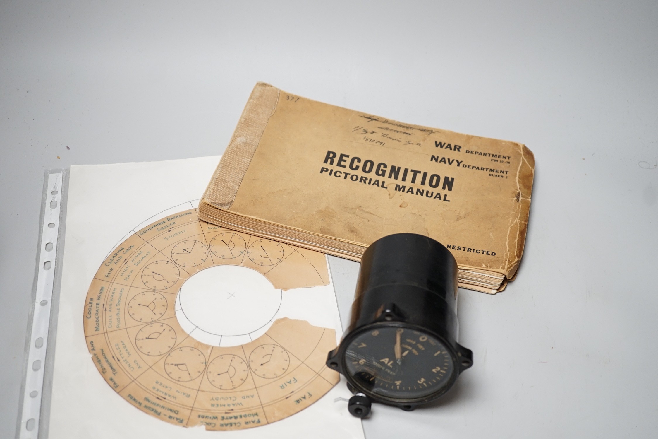 A WWII Air Ministry altimeter model XIV B and a War & Navy Department aircraft recognition pictorial manual